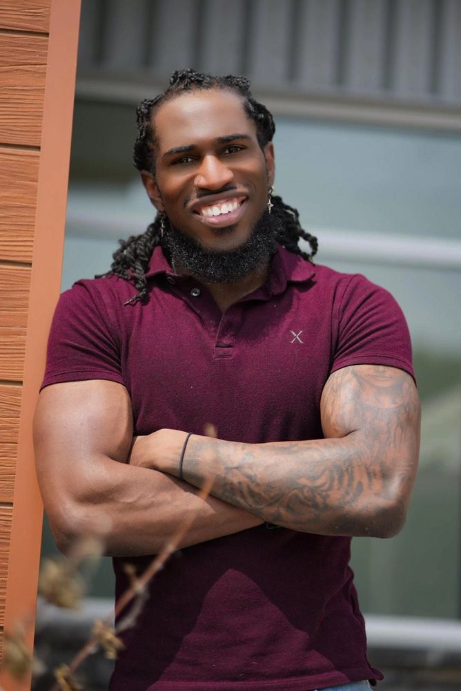 Kevin Thomas, the photographer behind KTJ Media, smiling with arms crossed in a maroon polo
