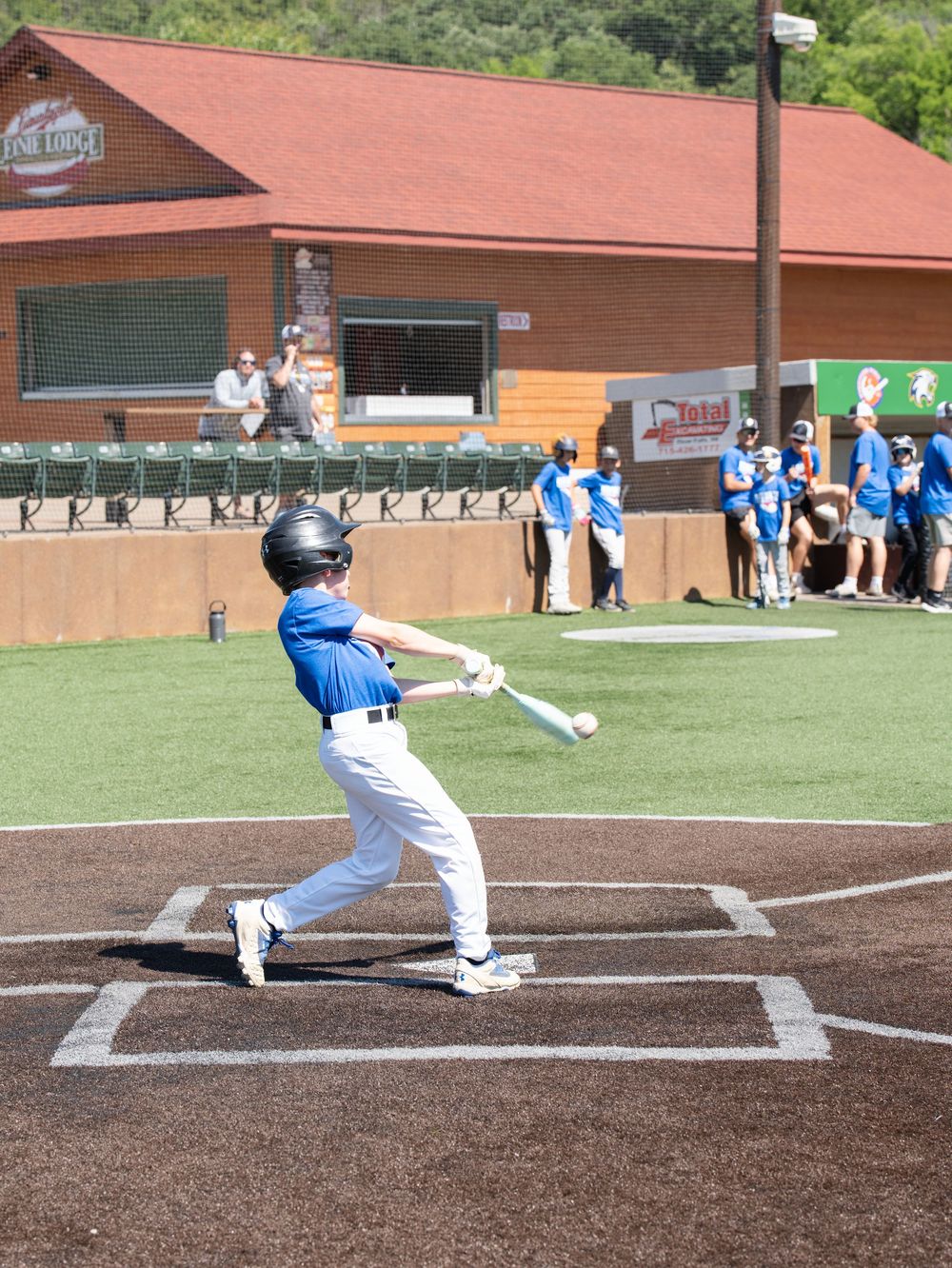 A young baseball player swinging at a pitch on a ballpark field during a youth event