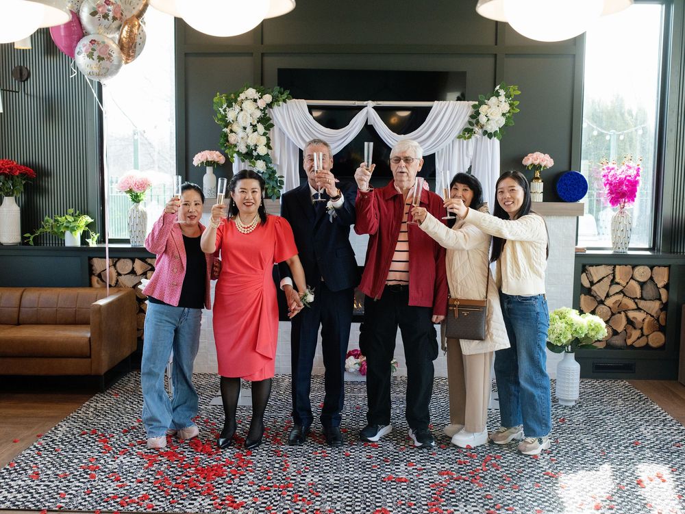A small group raising champagne glasses in a toast at an intimate celebration